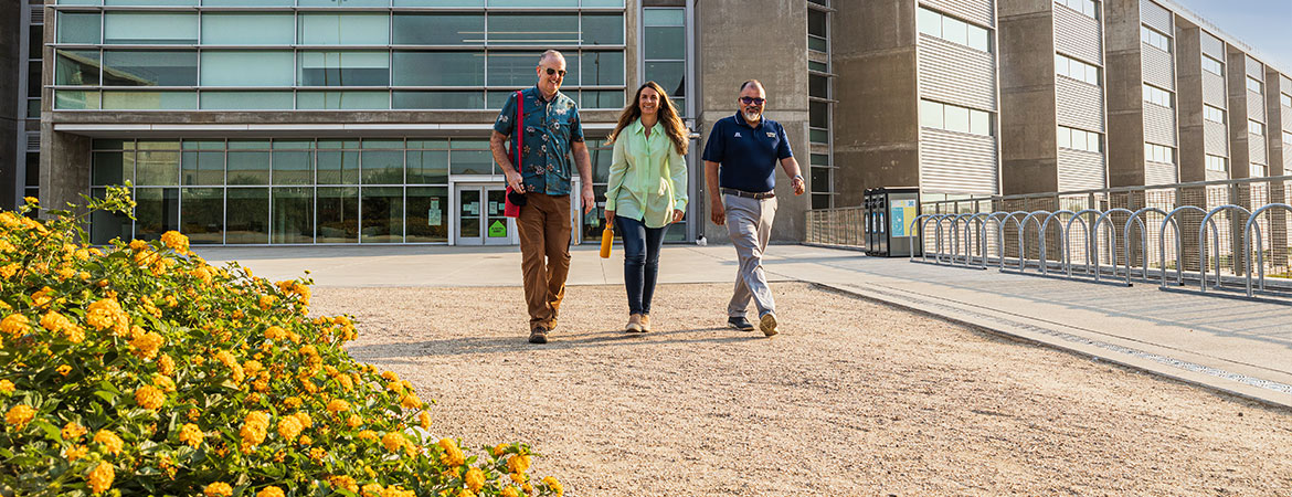 Trevor Hirst, Linda Hirst and Arturo Durazo taking a walk past Biomedical Sciences & Physics building, home of HSRI